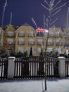 un edificio con un cartel en la nieve en Hotel Helena, en Giżycko