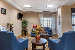 a waiting room with blue chairs and a table at Comfort Inn Downtown - University Area in Kalamazoo