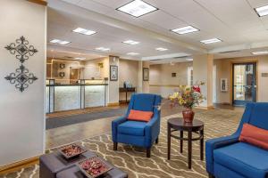 a waiting room with blue chairs and a table at Comfort Inn Downtown - University Area in Kalamazoo