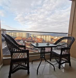 uma mesa e 2 cadeiras numa varanda com vista em Apartman DalMe em Novi Pazar