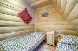 a room with two beds in a log cabin at Pokoje Pod Lasem in Kościelisko