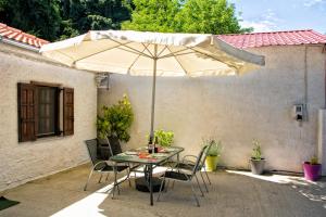 a table and chairs with an umbrella on a patio at Summer House by the Sea in Chorefto