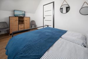 um quarto com uma cama com um cobertor azul em Chłapowska Przystań em Władysławowo