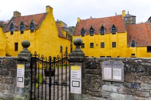 een geel gebouw met een hek ervoor bij Stunning & unique apt in Culross in Culross