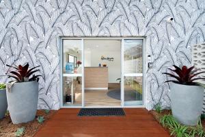 een draaideur in een kamer met potplanten bij Blue Heron Boutique Motel in Gold Coast