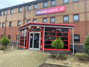 una cabina de teléfono rojo frente a un edificio en Premier Lodge, en Falkirk