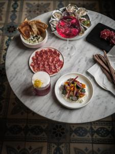 una mesa con platos de comida y una copa de vino en august, en Amberes