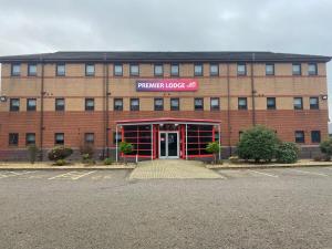 un gran edificio de ladrillo con un letrero rojo. en Premier Lodge, en Falkirk