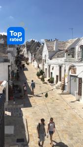 grupa ludzi idących ulicą w obiekcie Noù la tua casa in Puglia w Alberobello