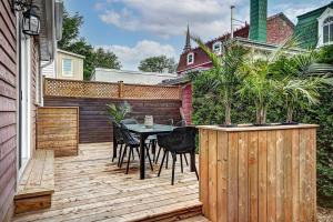 eine Terrasse mit einem Tisch und Stühlen auf einer Holzterrasse in der Unterkunft Maison 1900 - Confort au Vieux-Lévis in Lévis