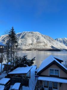 une maison recouverte de neige avec une montagne en arrière-plan dans l'établissement Appartement Emilia, à Hallstatt