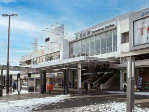 um centro comercial com pessoas andando na frente dele em Hotel Iidaya em Matsumoto