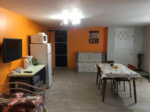 uma cozinha e sala de estar com uma mesa e um frigorífico em Gîte cosy à Ville-au-Val, proche Nancy et Metz, randonnées, 1 chambre, parking et terrain privé. - FR-1-584-111 em Ville-au-Val