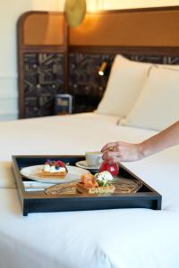 - un plateau avec deux assiettes de nourriture sur le lit dans l'établissement Only YOU Hotel Valencia, à Valence