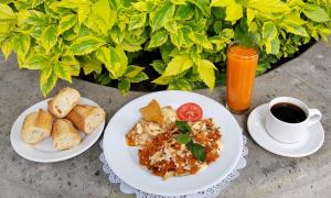 a table with two plates of food and a cup of coffee at Country Plaza in Guadalajara