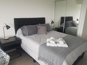 una camera da letto con un letto e asciugamani di Ocean Drive Country - Punta del Este a Punta del Este