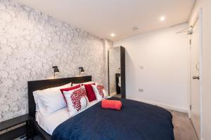 una camera da letto con un letto con cuscini rossi e bianchi di The Blossoms Studio Apartments a Liverpool