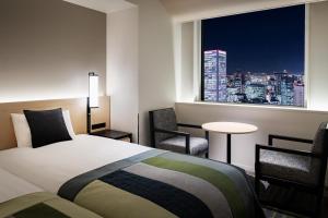 um quarto com uma cama e vista para a cidade em Hotel Hankyu RESPIRE OSAKA em Osaka