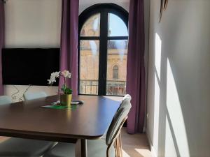 einen Esstisch mit einem Fenster und lila Vorhängen in der Unterkunft Apartamentos Vega by gaiarooms in Salamanca