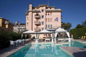 un hotel con piscina di fronte a un edificio di Ute Hotel a Lido di Jesolo