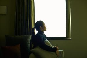 una mujer sentada en un sofá frente a una ventana en fav ISE, en Ise