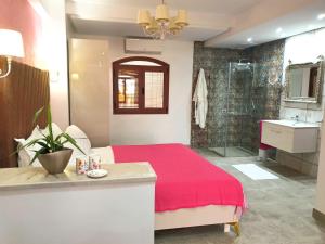 1 dormitorio con cama roja y baño en Mahdia - Baghdadi - Laourient Apartments, restaurant, café, en Mahdia