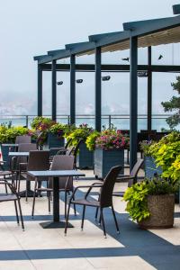 a patio with tables and chairs and plants on a building at Hotel Mrągowo Resort&Spa in Mrągowo