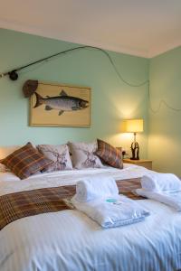 1 dormitorio con 1 cama con toallas en Tanglewood Lodge, en Lossiemouth