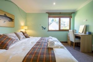 1 dormitorio con 1 cama y escritorio con ordenador en Tanglewood Lodge, en Lossiemouth