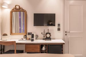 La salle de bains est pourvue d'un lavabo avec une horloge et un miroir. dans l'établissement Silo Luxury Rooms, à Nauplie