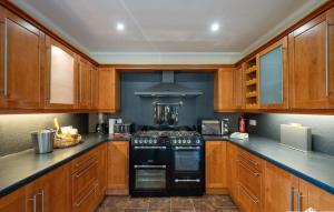 cocina con armarios de madera y estufa negra en Tanglewood Lodge, en Lossiemouth