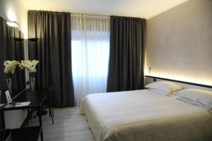 una camera con letto, scrivania e finestra di Brianteo Hotel and Restaurant a Burago di Molgora