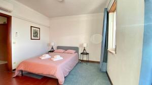 1 dormitorio con 1 cama con 2 toallas en Ericeira Panoramic Sea View Apartments, en Ericeira