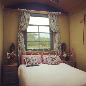 A bed or beds in a room at Sky View Shepherd's Huts with Woodburning Hot Tub