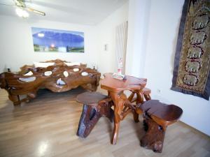 Cette chambre dispose de tables et de tabourets en bois. dans l'établissement Gästehaus Parkblick, à Rust