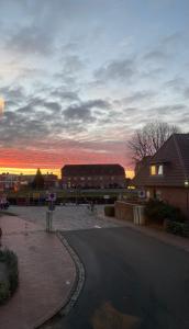 ein Sonnenuntergang über einem Parkplatz mit einem Gebäude in der Unterkunft Gasthaus Hafenblick in Tönning