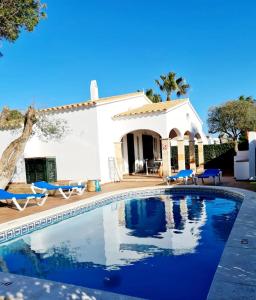 une villa avec une piscine en face d'une maison dans l'établissement Villas El Pinar, à Cala en Blanes