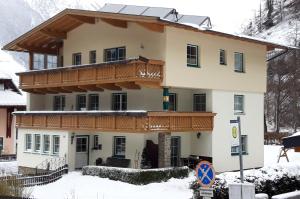 a house with a balcony in the snow at Haus Kristall in Längenfeld