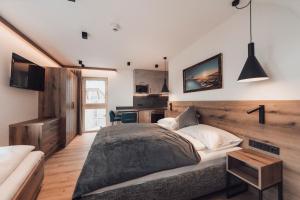 um quarto com uma cama grande e uma secretária em Alpenheim Apartment Ischgl em Ischgl