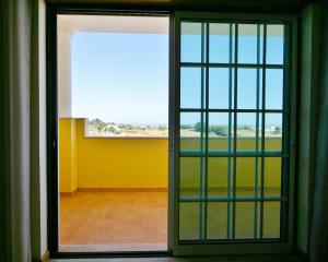 uma porta aberta para um quarto com uma janela em Villa Vista Mar Piscina Suites na Fuzeta