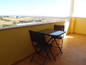 uma mesa e duas cadeiras num quarto com vista em Villa Vista Mar Piscina Suites na Fuzeta