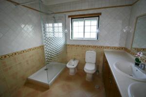 uma casa de banho com um WC, uma banheira e um lavatório. em Villa Vista Mar Piscina Suites na Fuzeta