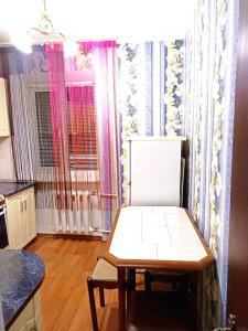 um quarto com uma mesa e uma cadeira em Уютные апартаменты c кондиционером на Уманчанке em Umanʼ