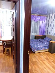 um quarto com uma cama, uma mesa e uma janela em Уютные апартаменты c кондиционером на Уманчанке em Umanʼ