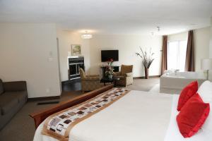 a bedroom with a large bed and a living room at Excelsior Hôtel Spa Sainte-Adèle in Sainte-Adèle