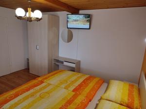 a small bedroom with a bed and a table at Gostilna Pension Blegoš in Poljane nad Škofjo Loko