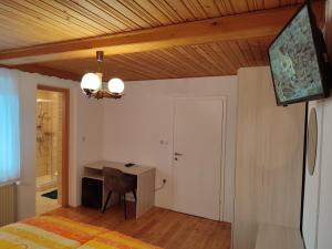 a bedroom with a bed and a desk and a television at Gostilna Pension Blegoš in Poljane nad Škofjo Loko