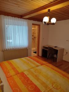 a bedroom with a large bed and a desk at Gostilna Pension Blegoš in Poljane nad Škofjo Loko