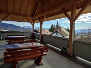 a group of benches sitting on a balcony with mountains at Gostilna Pension Blegoš in Poljane nad Škofjo Loko