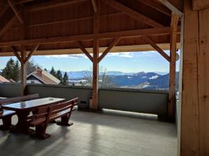 a patio with a table and a view of the mountains at Gostilna Pension Blegoš in Poljane nad Škofjo Loko